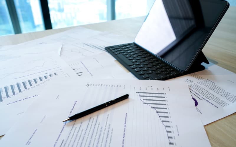 Laporan prestasi pelaburan dan tablet di atas meja mesyuarat